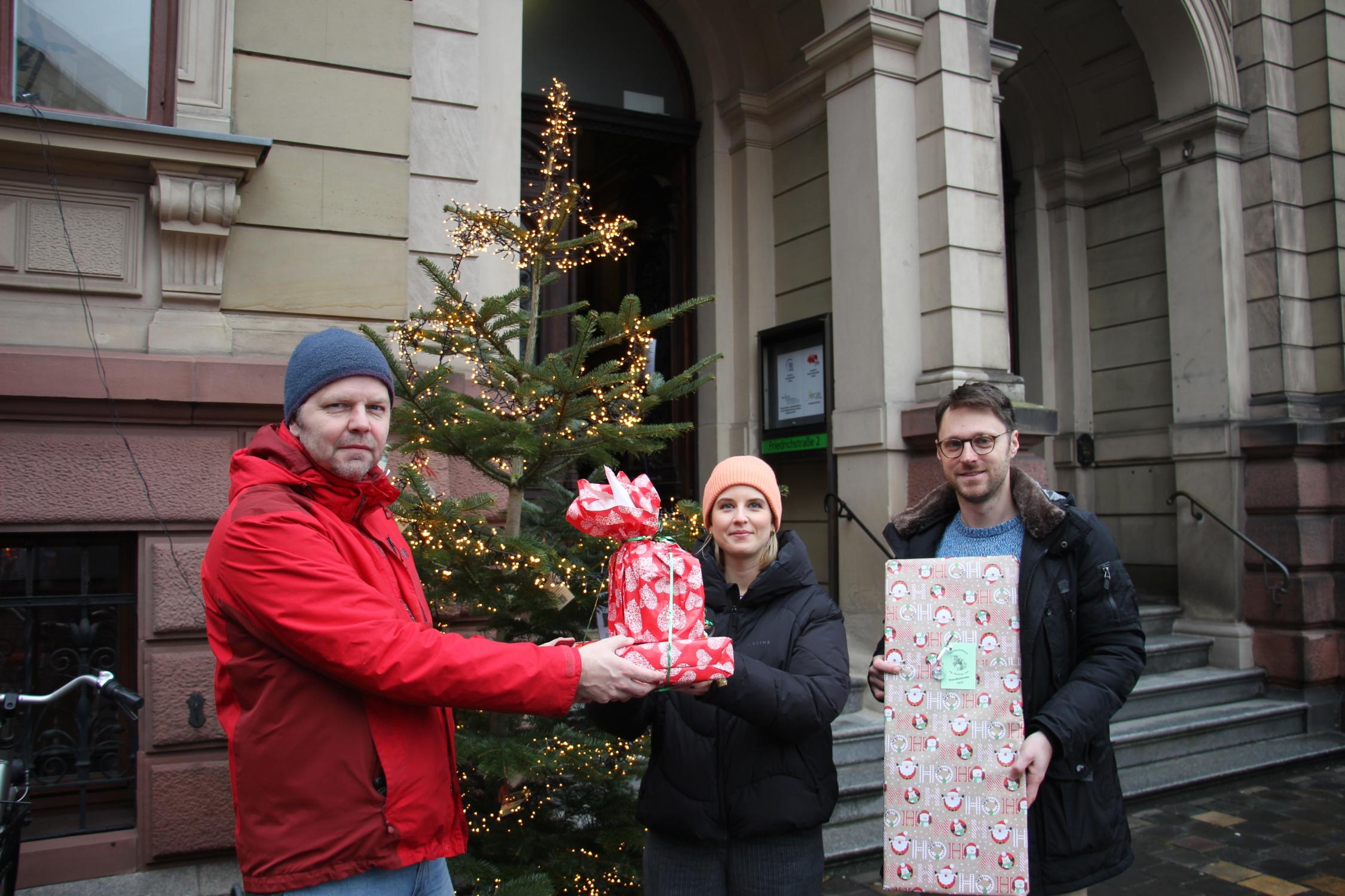 Vera Hawlitschek, Mitarbeiterin im Bereich Betreute Wohnformen des SkF freute sich zusammen mit den Hochschulseelsorgern Pfarrer Thomas Braun (l.) und Pater Severin Tyburski über die Geschenke aus der Christbaum-Aktion 2024.