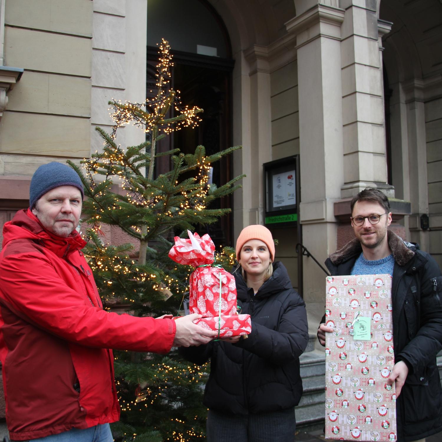 Vera Hawlitschek, Mitarbeiterin im Bereich Betreute Wohnformen des SkF freute sich zusammen mit den Hochschulseelsorgern Pfarrer Thomas Braun (l.) und Pater Severin Tyburski über die Geschenke aus der Christbaum-Aktion 2024.