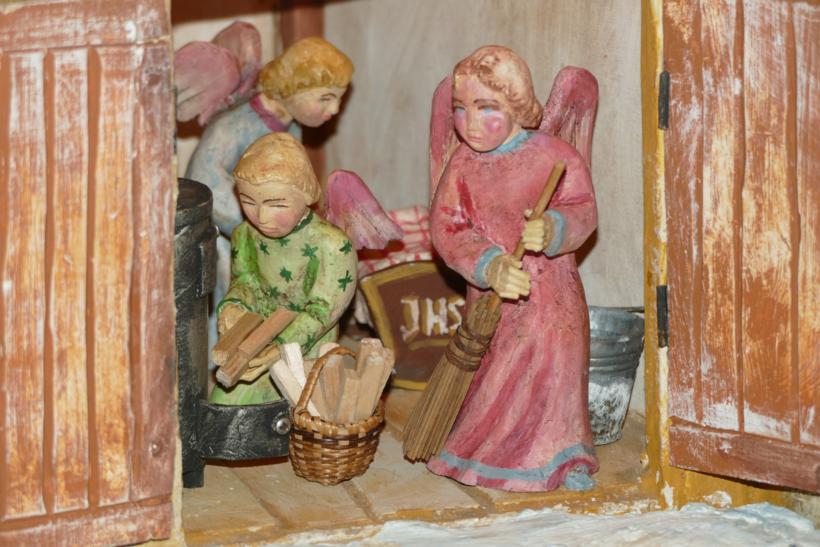 Engel bereiten den Stall für das Jesuskind vor, während Maria und Josef auf Herbergssuche sind.